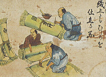 Historical depiction of Japanese craftsmen making traditional tatami mats. The image shows artisans weaving and preparing tatami, an essential part of Japanese culture and home design.